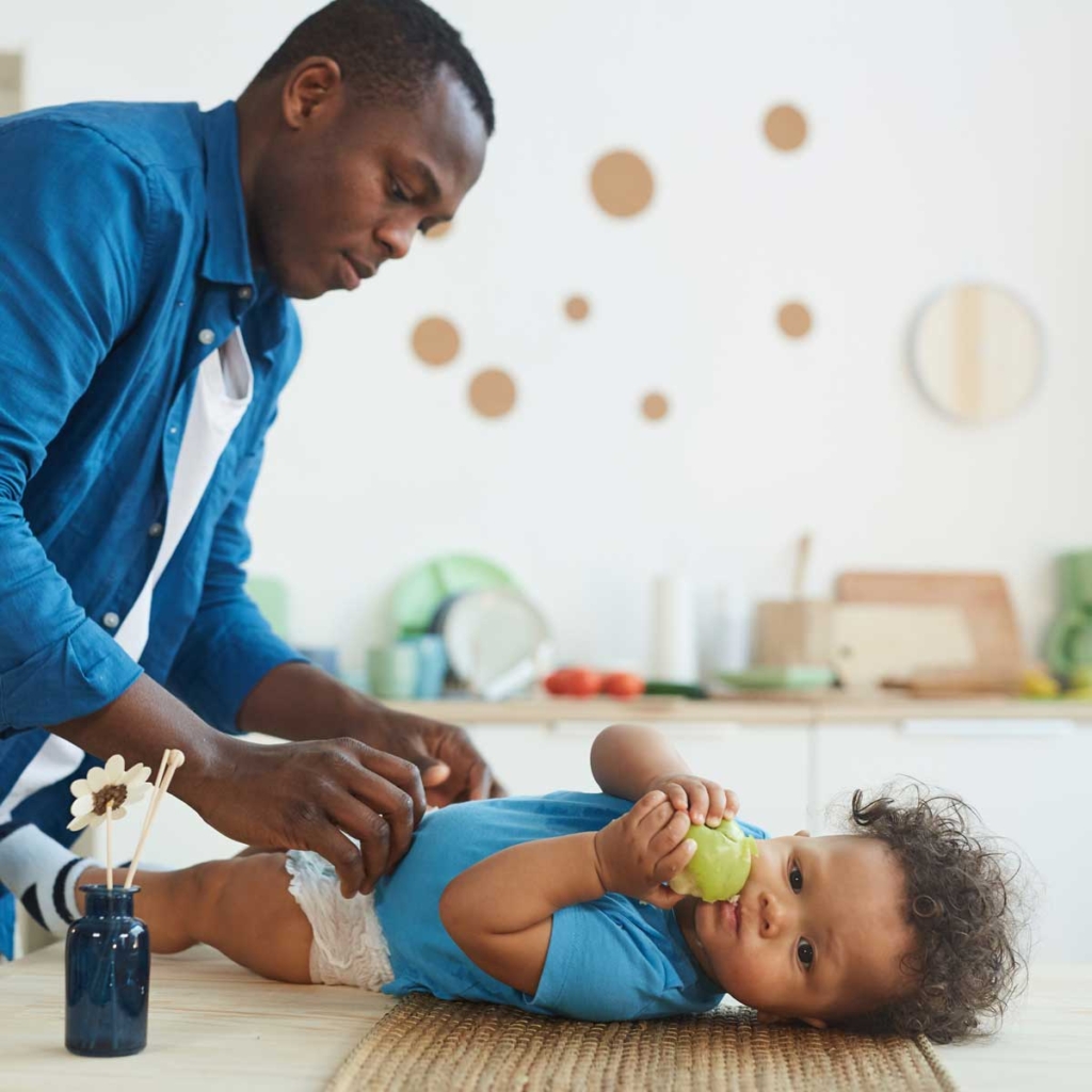 Father changing his son's diaper.